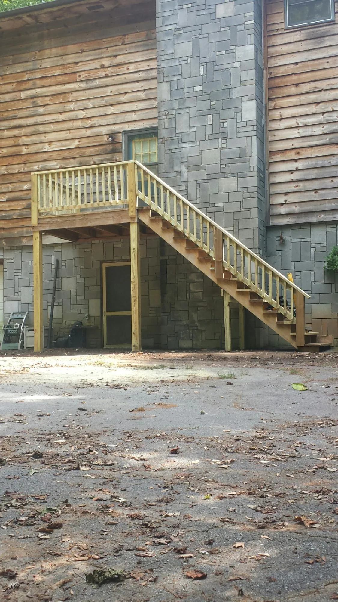 New pressure treated deck and stair landing on a log home in Village Mills