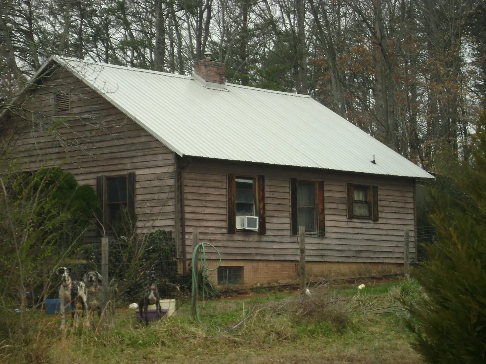 White metal roof on an old wood sided farmhouse, from a Metal Roof Installation job in Village Mills